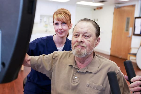 Therapist assisting resident with exercise equipment