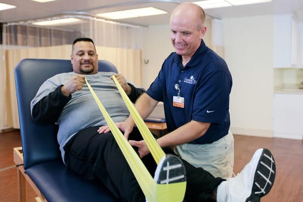 A resident engaging in physical therapy with a staff member