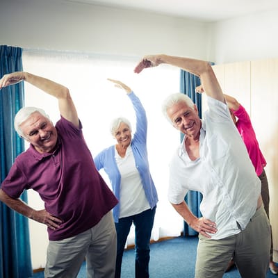 Seniors participating in a group exercise class indoors