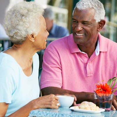 Two residents enjoying coffee and pastries outdoors