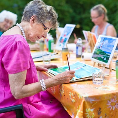 Resident painting outside during an art activity