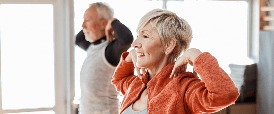Seniors participating in a group exercise activity indoors