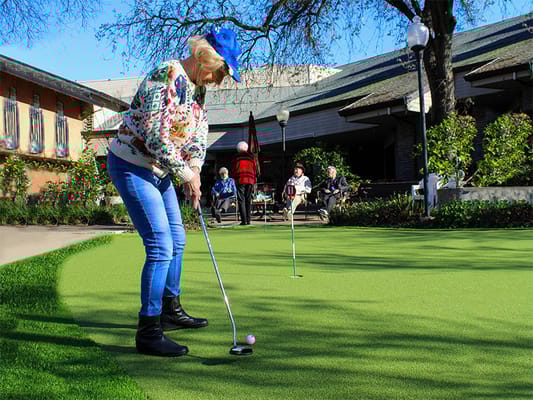 Resident enjoying outdoor putting green
