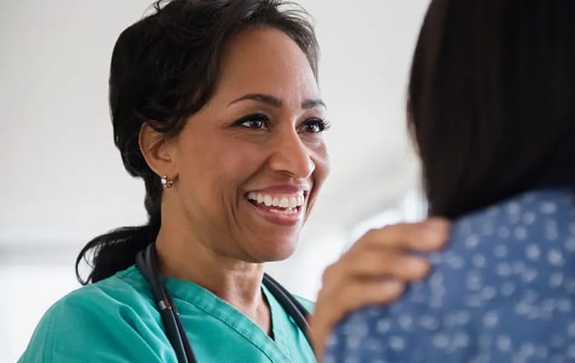 A healthcare worker smiling at a resident