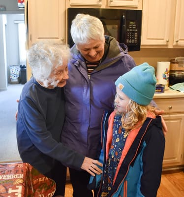 Residents and a child interacting in a warm kitchen