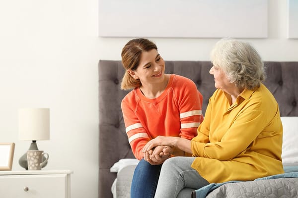 A caregiver and an elder woman sharing a moment in a room