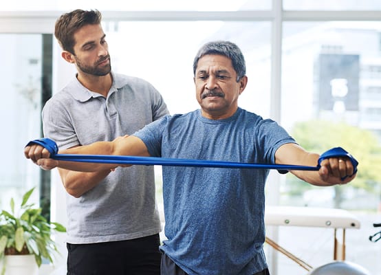 A resident engaging in physical therapy with a staff member