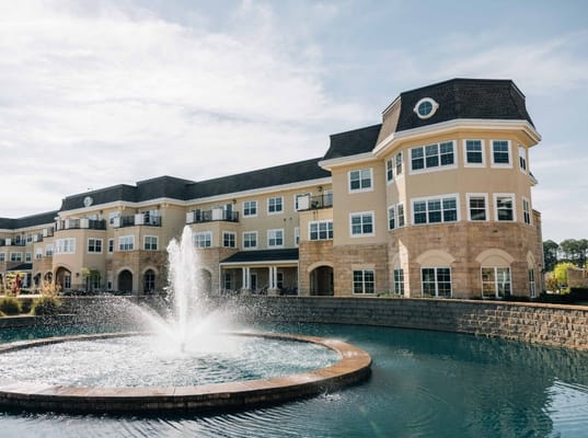 Exterior view of the Searstone Retirement Community building and fountain