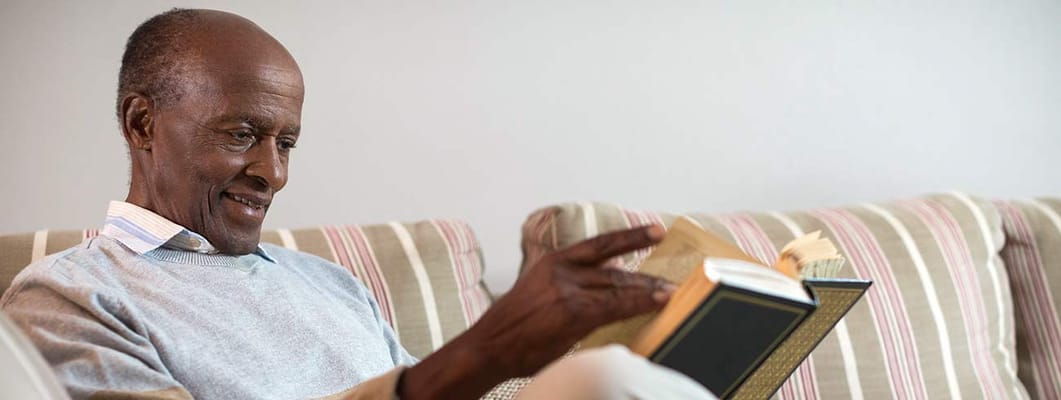A senior man enjoying reading on a couch