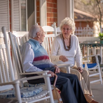 Two residents enjoying a conversation on a porch