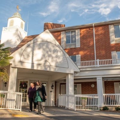 Two women walking towards the entrance of the facility