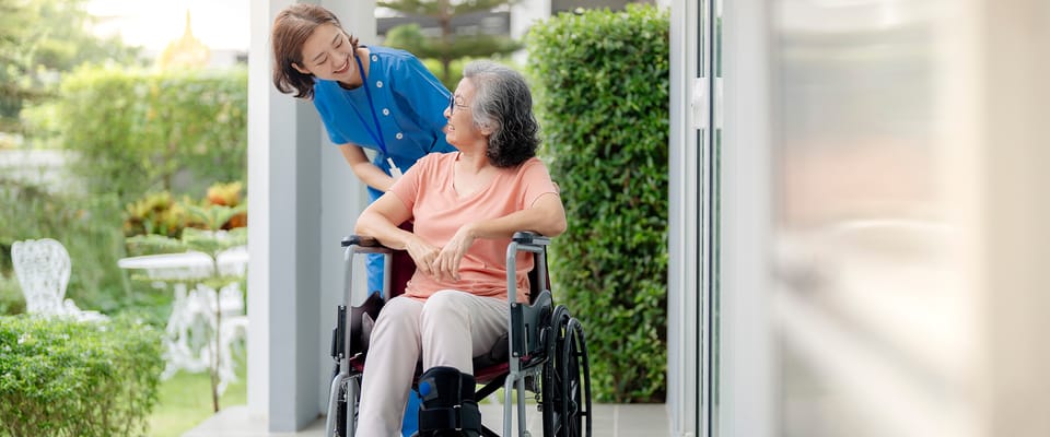 A caregiver helps a resident in a wheelchair