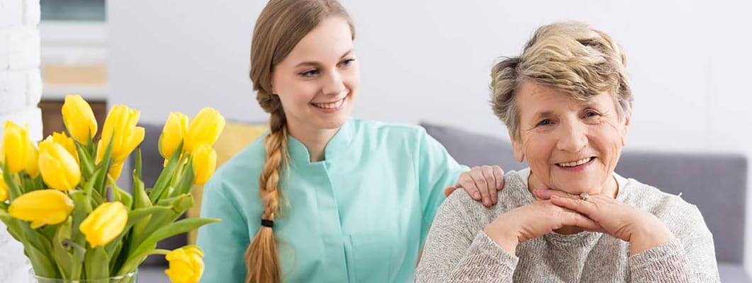 A caregiver smiling with a resident in a bright interior