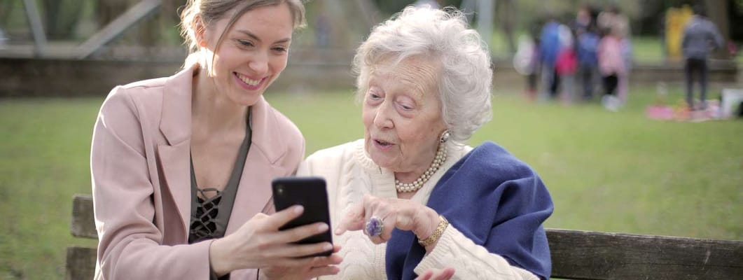 A senior resident and staff member sharing a moment outdoors