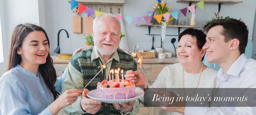 Residents and staff celebrating with a birthday cake