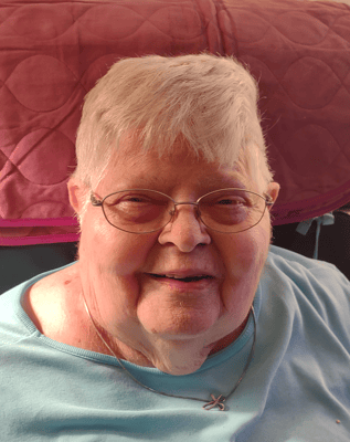 A smiling elderly woman in a blue shirt