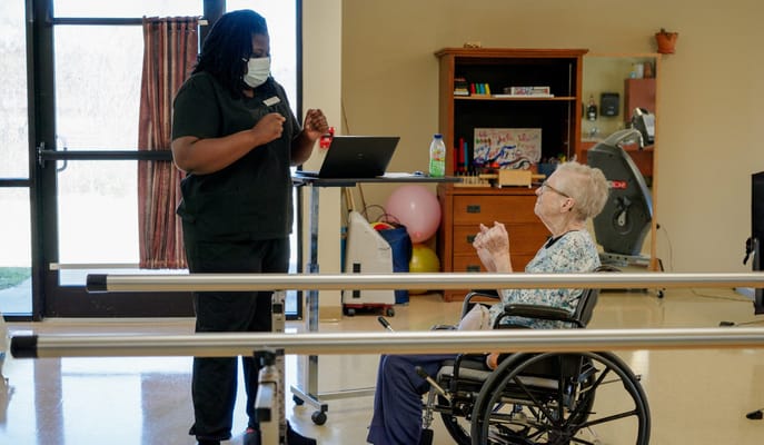 Therapist assisting a resident in a bright activity room