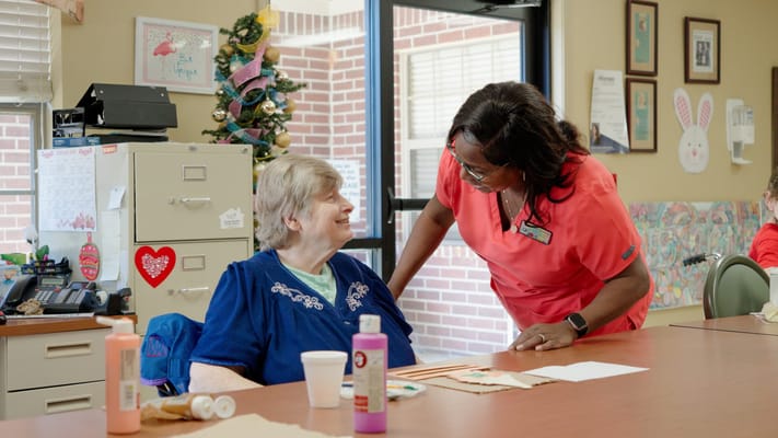 Staff member engaging with a resident in an activity room