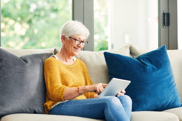 Senior woman using a tablet on a sofa