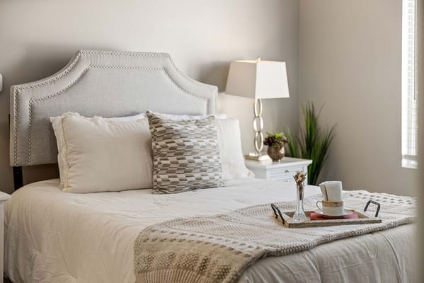 Cozy resident room with a neatly made bed and snack tray