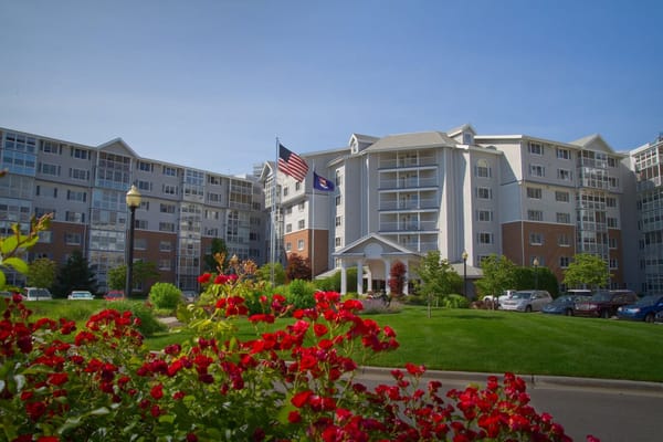 Exterior view of a senior living facility with flowers and flags