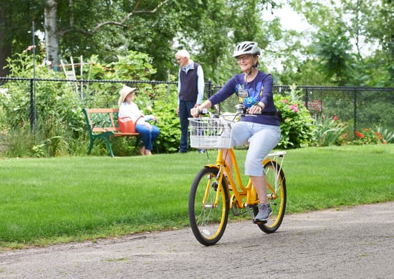 Resident riding a bicycle in a garden area.