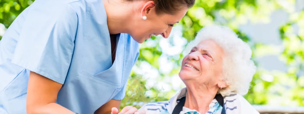 Caregiver interacting with an elderly resident outdoors