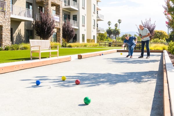 Residents playing bocce ball in a sunny outdoor space