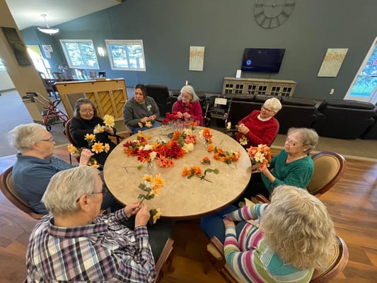 Residents engaged in a flower arrangement activity.