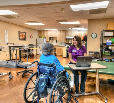 A staff member interacting with a resident in an activity room
