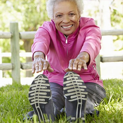 Senior woman stretching outdoors in a park