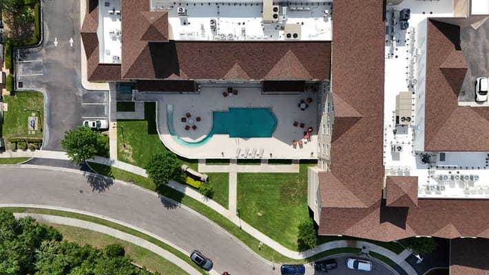 Aerial view of a swimming pool surrounded by seating at Discovery Village At Tampa Palms.