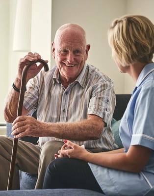 Elderly man chatting with a caregiver in a cozy setting