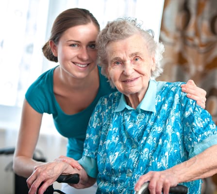 A caregiver smiling with an elderly resident in an indoor setting