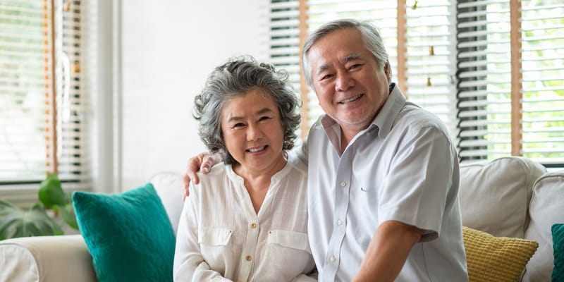 Senior couple smiling together on a couch