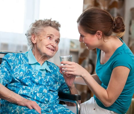 Caregiver assisting a resident with a drink