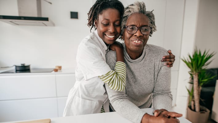 Staff member embracing a resident in a cozy kitchen