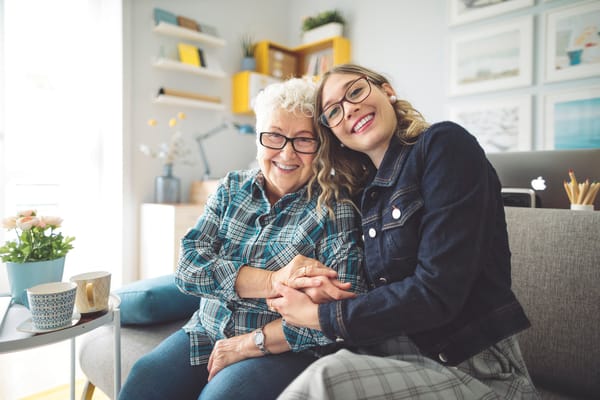 Senior resident with caregiver in a cozy living room