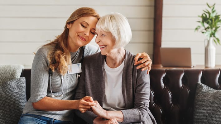 A caregiver embracing a resident in a cozy living area