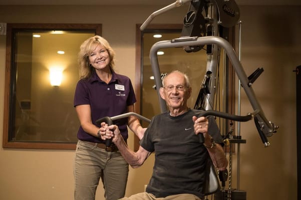 Staff assisting a resident in an exercise area