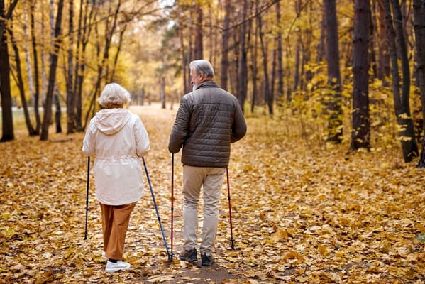 Two seniors walking in a picturesque autumn park