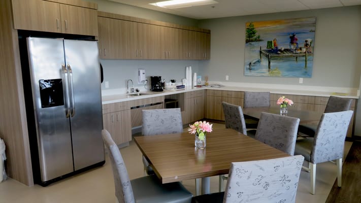 Brightly lit kitchen and dining space with tables and chairs