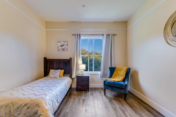 Cozy private room with a bed and armchair