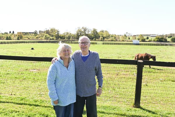 Two residents enjoying a sunny day outdoors near a horse