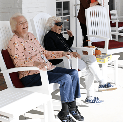 Residents enjoying time outdoors in rocking chairs