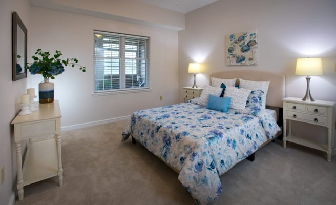 A cozy bedroom with floral bedding and soft lighting.