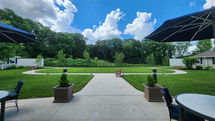 Beautiful landscaped outdoor space with benches and patio umbrellas