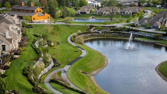 Aerial view of a scenic community with walking paths and water features