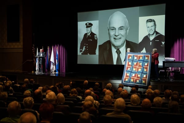 Residents attending a commemorative event with a presentation