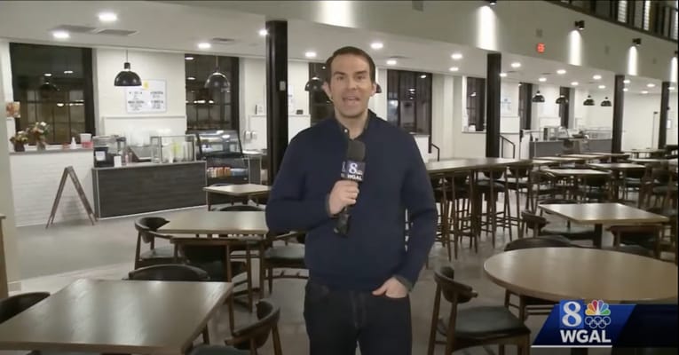 TV host speaking in a dining area of a facility